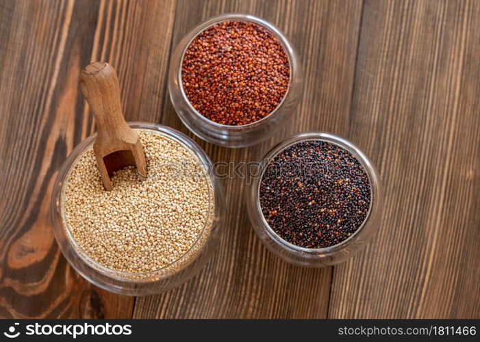 Different kinds of quinoa on wooden background