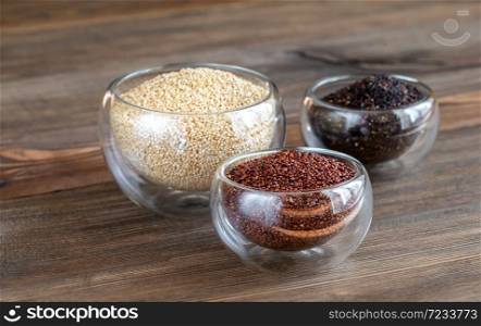 Different kinds of quinoa on wooden background