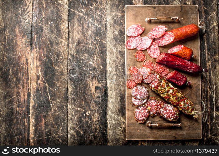 Different kinds of salami on the boards. On a wooden background.. Different kinds of salami on the boards.