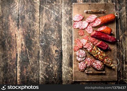 Different kinds of salami on the boards. On a wooden background.. Different kinds of salami on the boards.