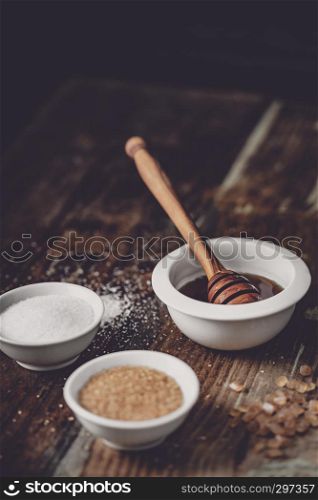 different kinds of sugar and maple syrup on a dark background