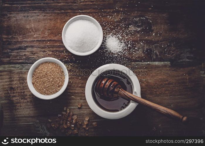 different kinds of sugar and maple syrup on a dark background