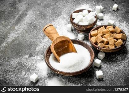 Different kinds of sugar in bowls. On a rustic background.. Different kinds of sugar in bowls.