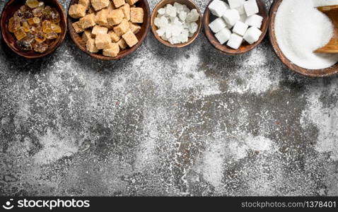 Different kinds of sugar in bowls. On a rustic background.. Different kinds of sugar in bowls.