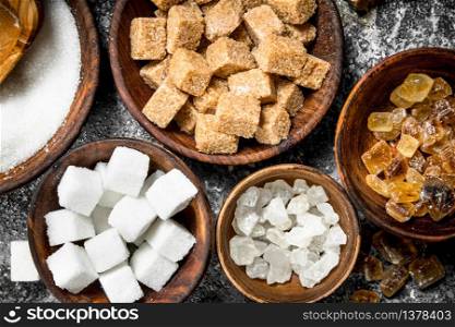 Different kinds of sugar in bowls. On a rustic background.. Different kinds of sugar in bowls.