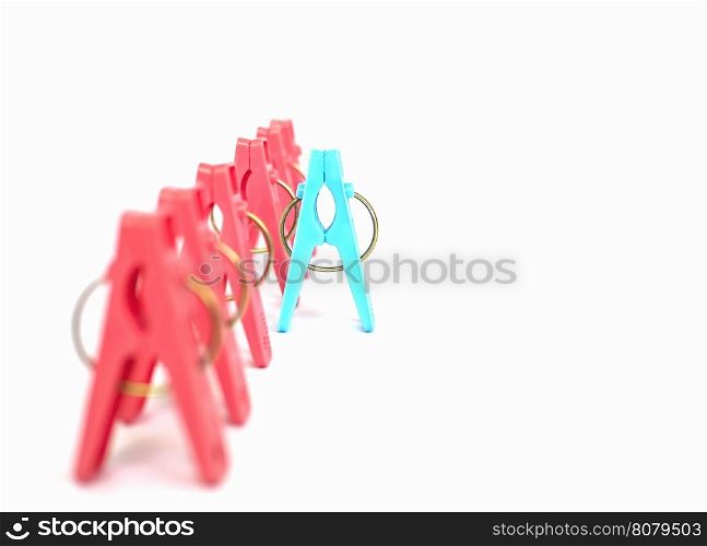 Different or competition concept using colorful plastic clothespins over white background
