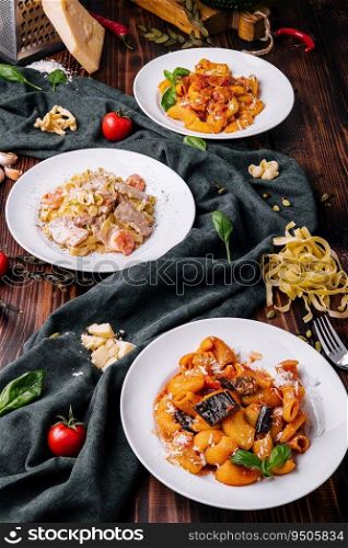 different pasta dishes on wooden with fabric background