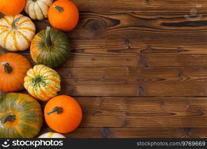 Different pumpkins on a wooden background, autumn theme, texture. Design ideas, top view. Halloween, Thanksgiving day. Pumpkins on wooden background