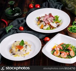 different salads in white plates on a wooden table