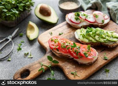 Different sandwiches with vegetables and microgreens. Healthy food