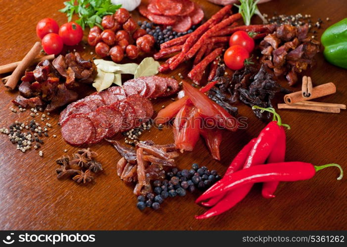 different sausage and meat on a celebratory table with spices and vegetables