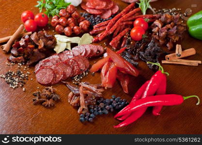 different sausage and meat on a celebratory table with spices and vegetables