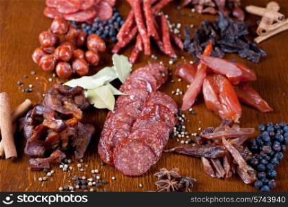 different sausage and meat on a celebratory table with spices and vegetables. meat and sausages