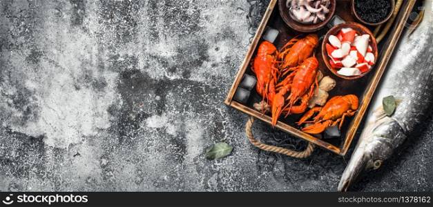 Different seafood on a wooden tray. On a rustic background.. Different seafood on a wooden tray.