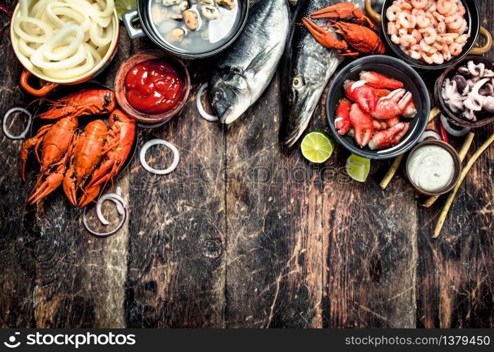 Different seafood on table. On a wooden background.. Different seafood on table.