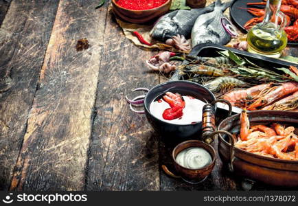 Different seafood with shrimps and red caviar. On a wooden background.. Different seafood with shrimps and red caviar.