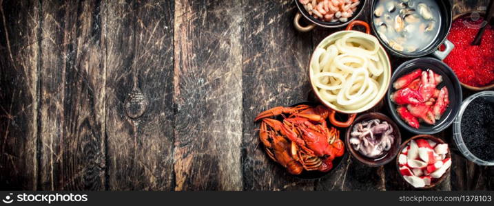 Different seafood with shrimps and red caviar. On a wooden background.. Different seafood with shrimps and red caviar.