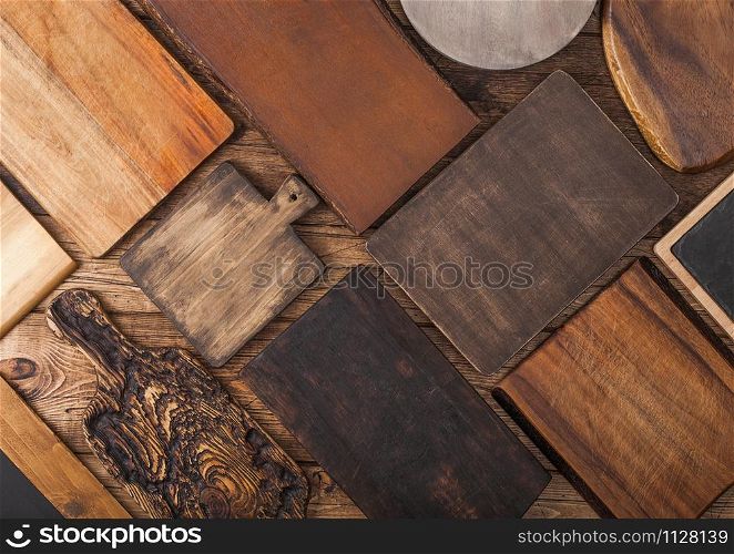 Different sizes and shapes kitchen chopping boards on wood background.