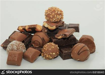 Different sorts of chocolates: bonbons and broken pieces of a chocolate bar