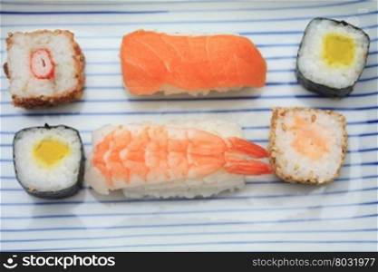 Different sorts of sushi, served on a Japanese plate