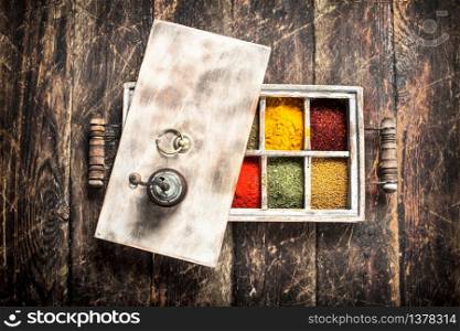Different spices and herbs in a box. On a wooden background.. Different spices and herbs in a box.