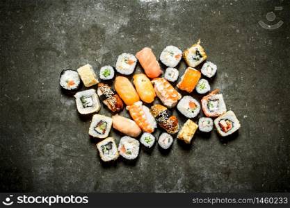 Different sushi and rolls with seafood. On the stone table.. Different sushi and rolls with seafood.