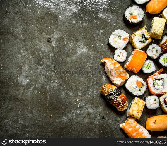 Different sushi and rolls with seafood. On the stone table.. Different sushi and rolls with seafood.