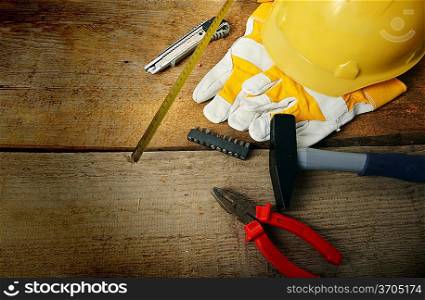 Different tools and gloves on wooden background.