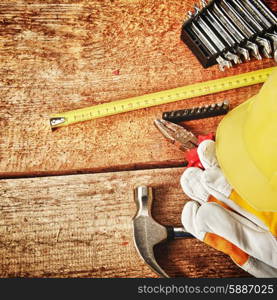 Different tools and gloves on wooden background.