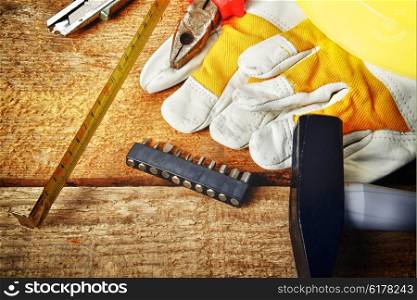 Different tools and gloves on wooden background.