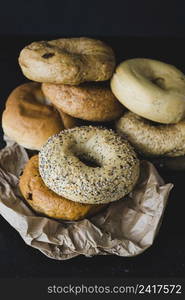 different type bagels crumpled brown paper black background