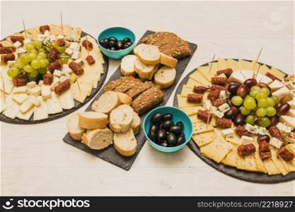 different type bread slices with olives platter cheese wooden desk
