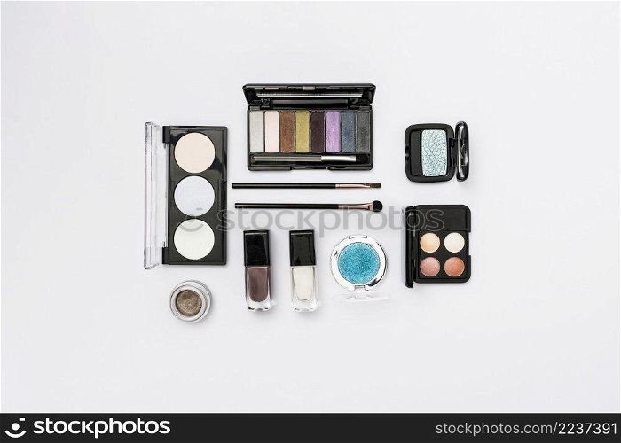 different type cosmetics palette with makeup brushes white background