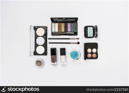different type cosmetics palette with makeup brushes white background