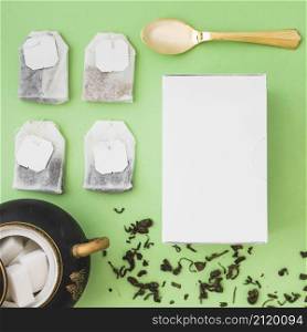 different type herbal tea bags sugar cubes spoon white box colored background