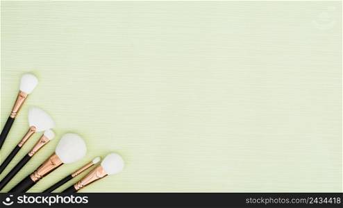 different type white makeup brushes corner green mint background