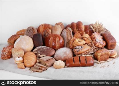 Different types of baked goods on linen and white wall background.. Different types of baked goods on linen and white wall background