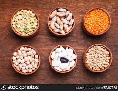 Different types of beans in wooden bowls