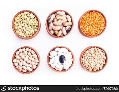 Different types of beans in wooden bowls isolated on white. Types of beans