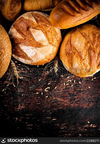 Different types of bread with spikelets. Against a dark background. High quality photo. Different types of bread with spikelets.