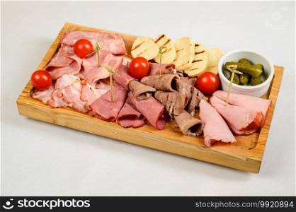 Different types of chopped sausages on a wooden board on white background. Different types of sausages served on white background