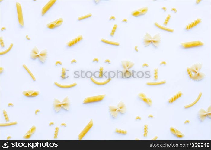 Different types of dry pasta on white background