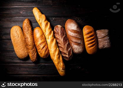 Different types of fresh crispy bread. On a wooden background. High quality photo. Different types of fresh crispy bread.