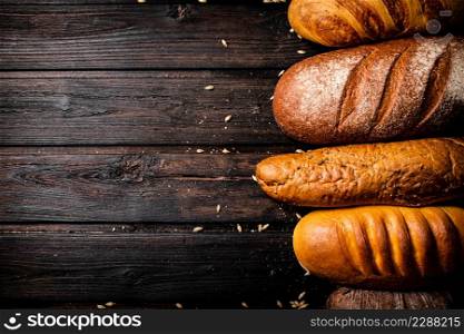 Different types of fresh crispy bread. On a wooden background. High quality photo. Different types of fresh crispy bread.