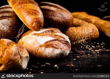 Different types of fresh homemade bread. On a black background. High quality photo. Different types of fresh homemade bread.