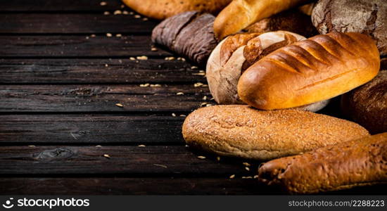 Different types of freshly baked bread. On a wooden background. High quality photo. Different types of freshly baked bread.