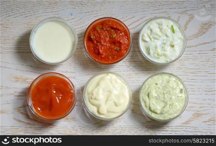 different types of sauces on wooden table