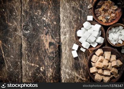 Different types of sugar in bowls. On a wooden background.. Different types of sugar in bowls.