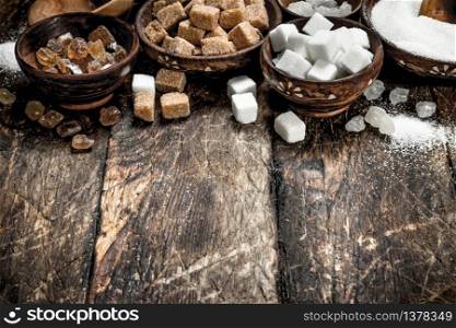 Different types of sugar in bowls. On a wooden background.. Different types of sugar in bowls.