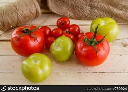 different types of tomatoes on a light wooden background